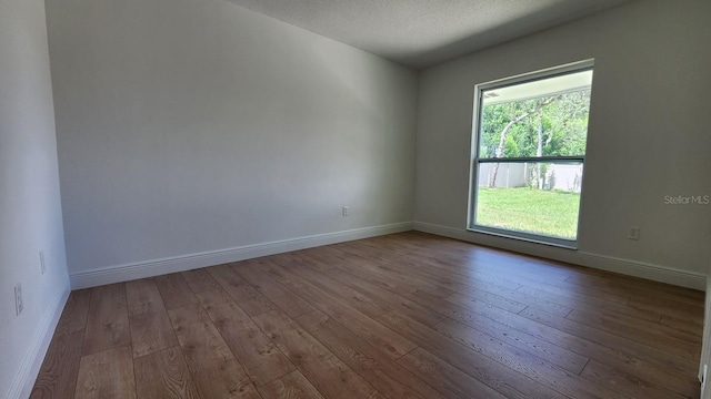 unfurnished room with a textured ceiling and light hardwood / wood-style flooring