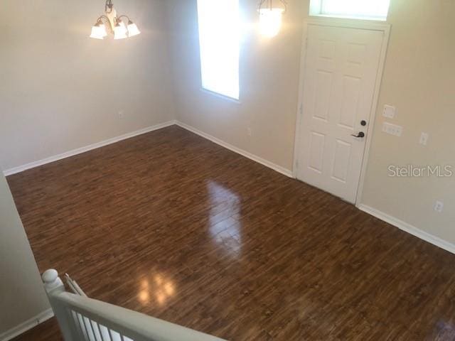 interior space featuring dark wood-type flooring and a chandelier