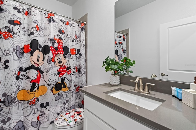 bathroom with vanity, curtained shower, and toilet