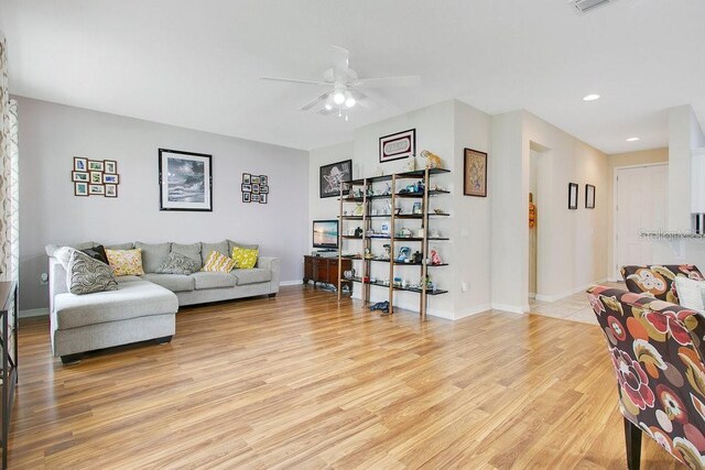 living room featuring ceiling fan and light hardwood / wood-style flooring