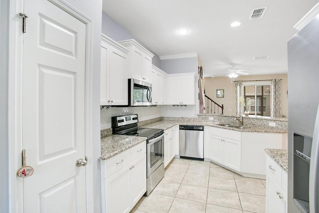 kitchen featuring appliances with stainless steel finishes, ceiling fan, light tile patterned floors, and light stone counters