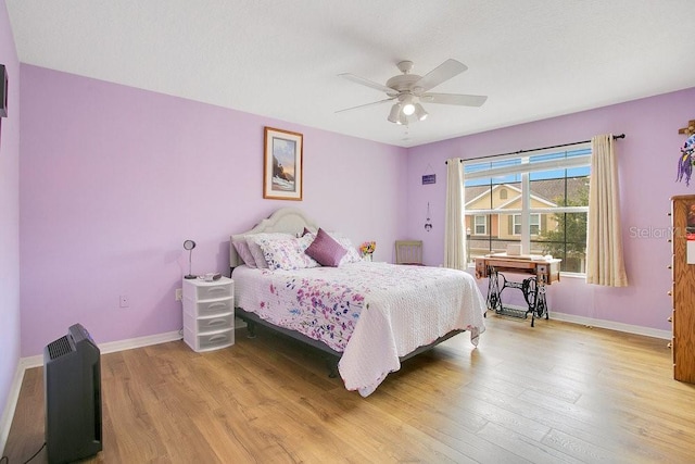 bedroom with light hardwood / wood-style floors and ceiling fan