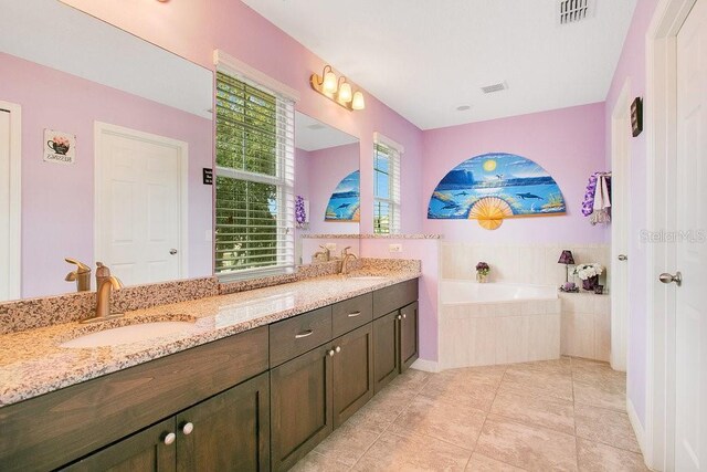 bathroom with a relaxing tiled tub, tile patterned flooring, and dual bowl vanity