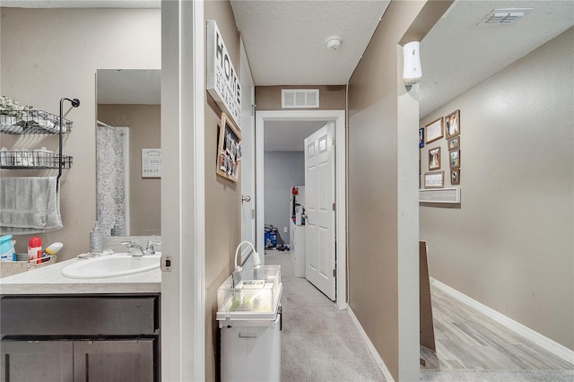 bathroom featuring vanity, a textured ceiling, and wood-type flooring