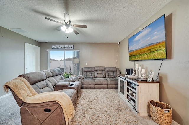 living room featuring light colored carpet, ceiling fan, and a textured ceiling