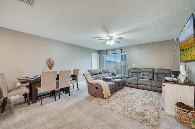 living room featuring ceiling fan, carpet, and a textured ceiling