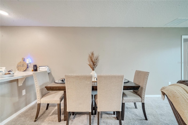 dining room featuring a textured ceiling and carpet