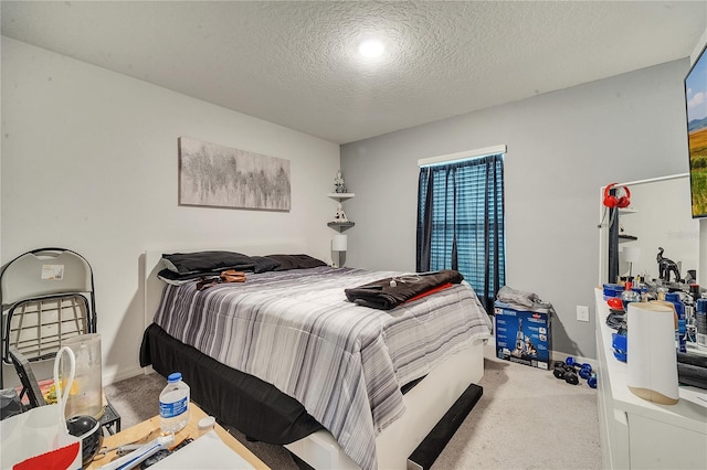 bedroom with a textured ceiling and light colored carpet