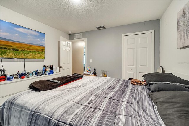 bedroom featuring a textured ceiling and a closet