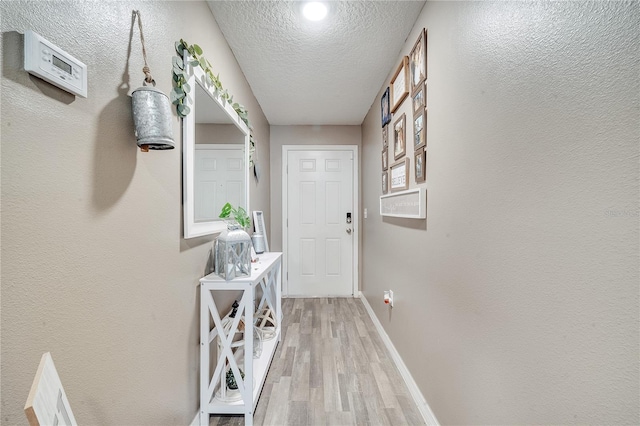 entryway with a textured ceiling and hardwood / wood-style flooring