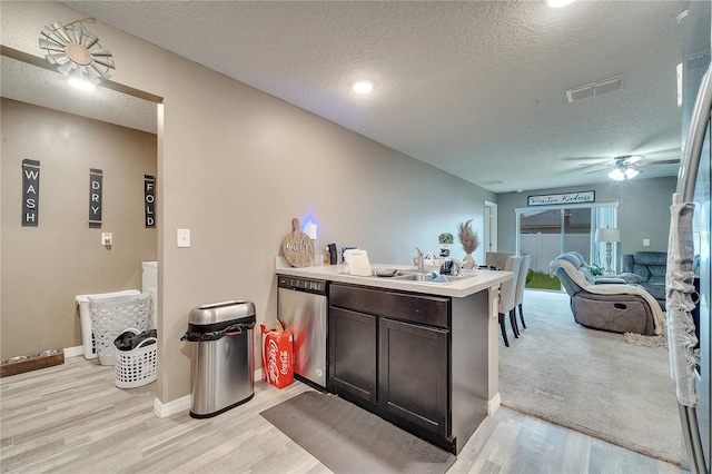 kitchen with dishwasher, light wood-type flooring, a textured ceiling, and ceiling fan