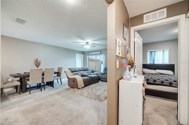 carpeted living room featuring a textured ceiling and ceiling fan