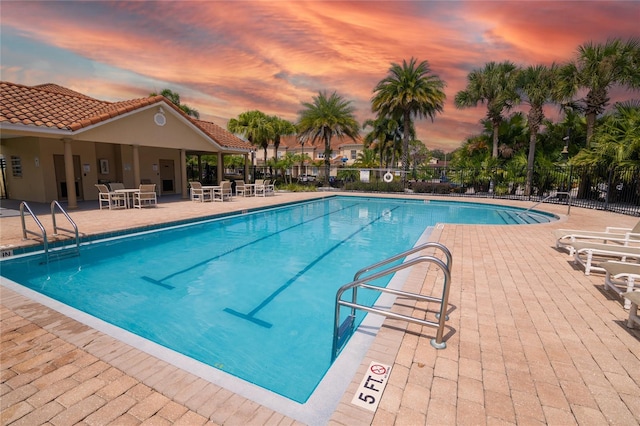 pool at dusk with a patio