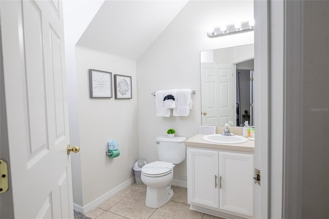 bathroom with tile patterned floors, toilet, vanity, and vaulted ceiling