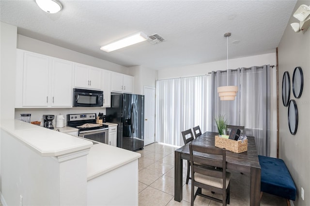 kitchen featuring a textured ceiling, white cabinets, black appliances, light tile patterned flooring, and kitchen peninsula