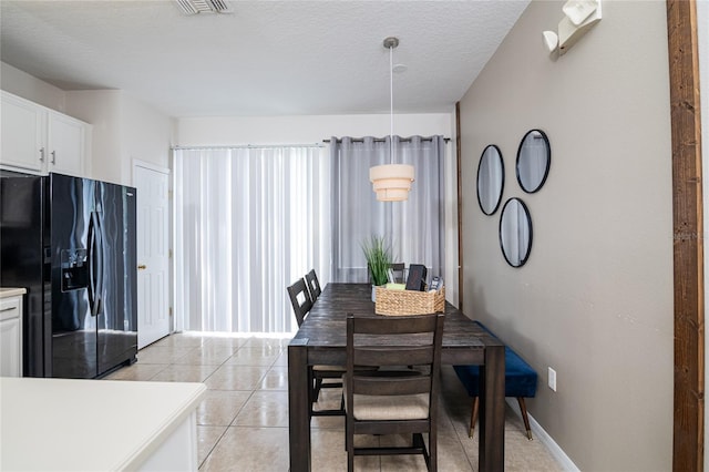 dining space with light tile patterned floors and a textured ceiling