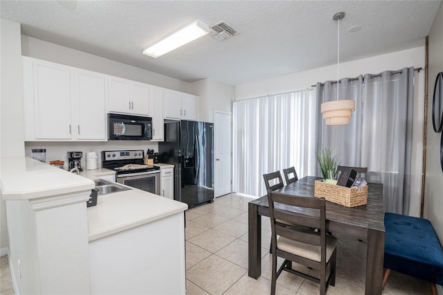 kitchen with white cabinets, light tile patterned flooring, black appliances, and a textured ceiling