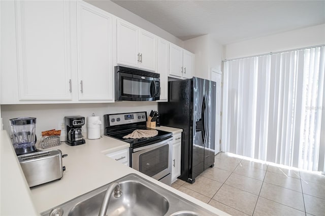 kitchen with white cabinetry, a textured ceiling, black appliances, and light tile patterned floors