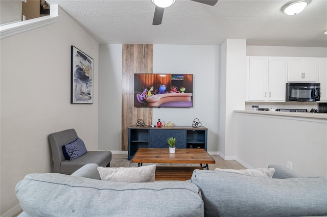 living room with a textured ceiling and ceiling fan