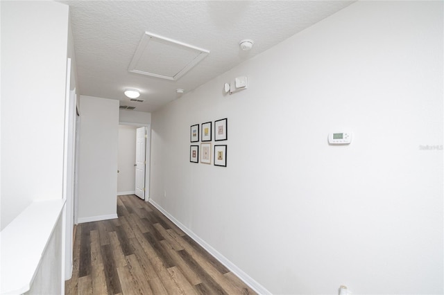 hallway featuring dark wood-type flooring and a textured ceiling