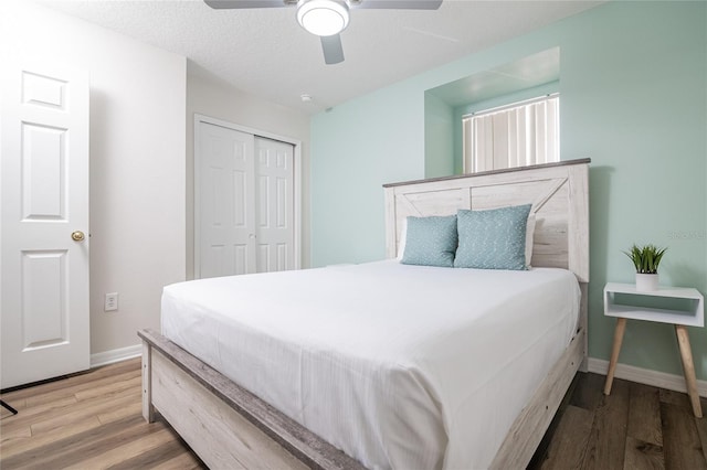 bedroom featuring hardwood / wood-style flooring, ceiling fan, a textured ceiling, and a closet