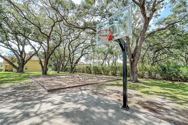 view of basketball court with a yard