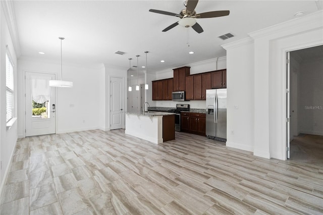 kitchen featuring appliances with stainless steel finishes, an island with sink, hanging light fixtures, ornamental molding, and ceiling fan