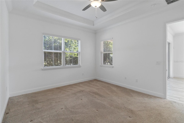 unfurnished room with ceiling fan, ornamental molding, a tray ceiling, and light carpet