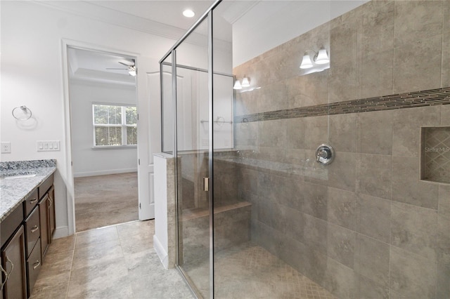 bathroom featuring a shower with shower door, vanity, ceiling fan, crown molding, and tile patterned floors