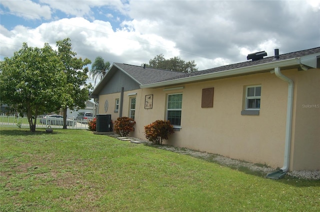 view of side of home with a yard and central AC unit