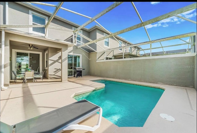 view of pool with grilling area, ceiling fan, a patio area, and a lanai