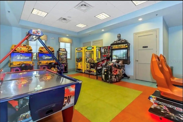 game room with a drop ceiling and a tray ceiling