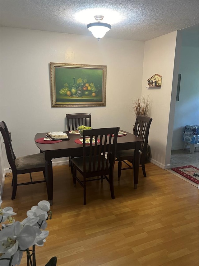 dining room featuring a textured ceiling and wood-type flooring