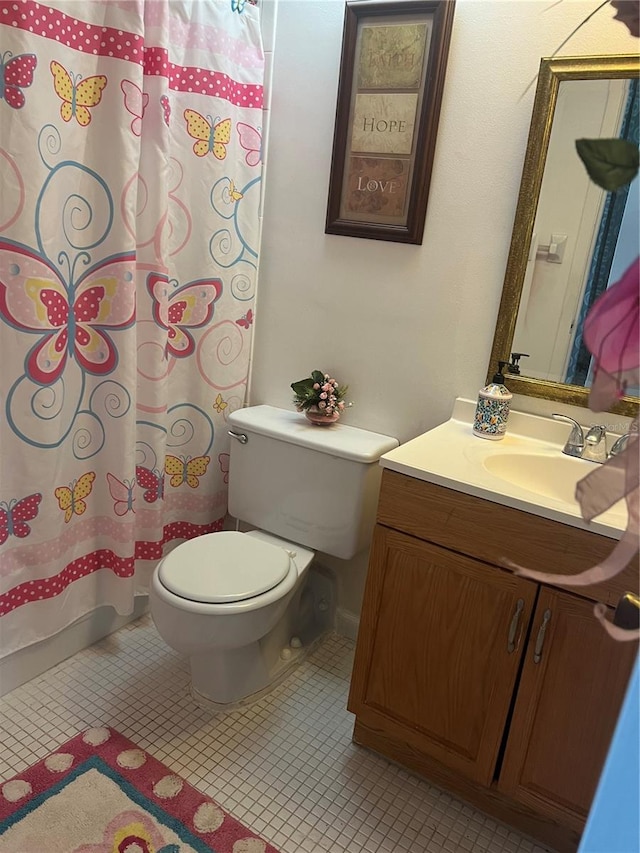 bathroom featuring vanity, tile patterned flooring, and toilet