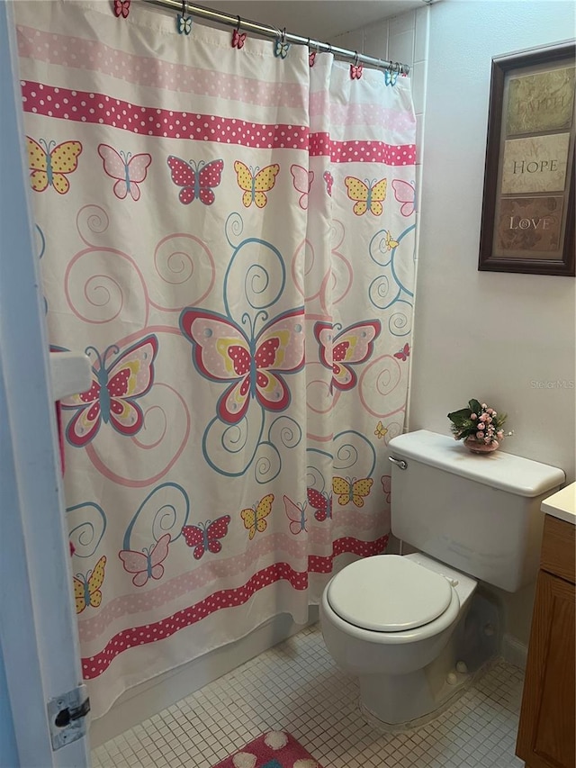 bathroom featuring tile patterned flooring, toilet, and vanity