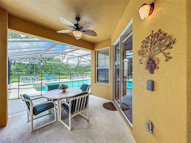 view of patio / terrace with ceiling fan and glass enclosure