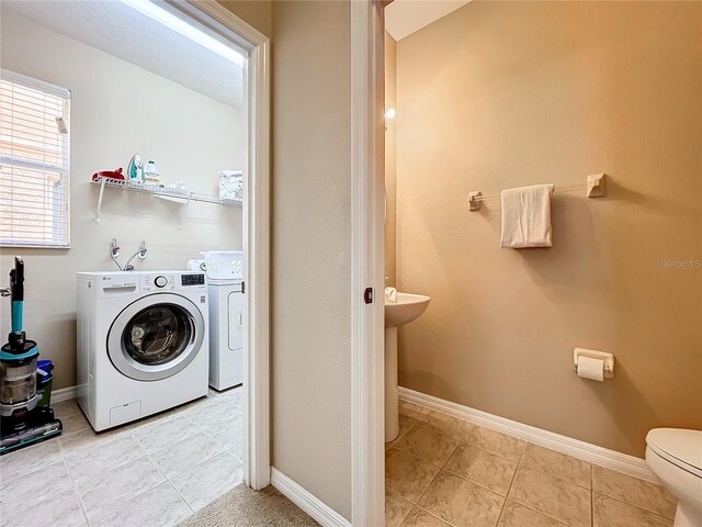 laundry room featuring light tile patterned floors and washer and dryer