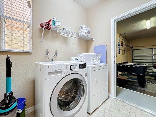 washroom featuring light tile patterned flooring and washer and dryer