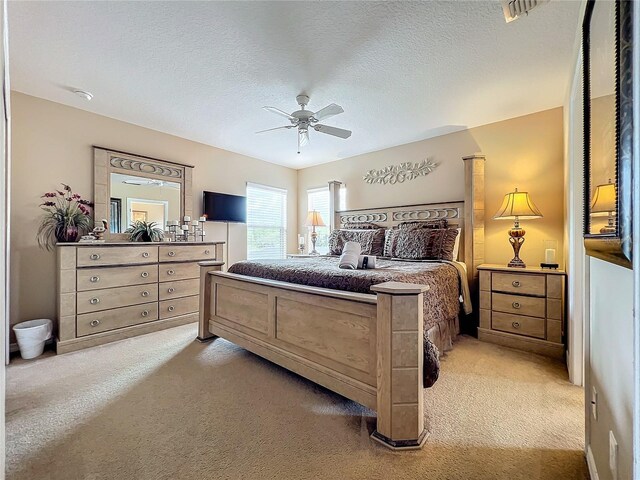 carpeted bedroom featuring a textured ceiling and ceiling fan