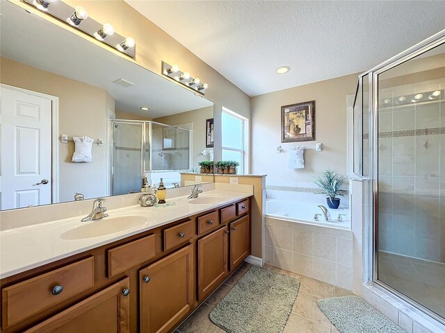 bathroom with shower with separate bathtub, tile patterned flooring, a textured ceiling, and vanity