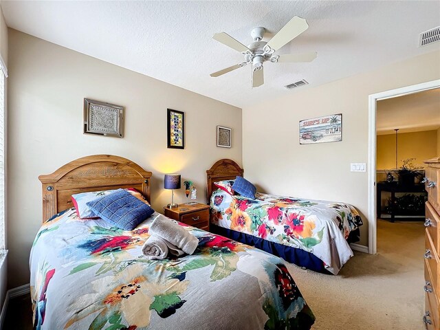 bedroom featuring carpet floors, ceiling fan, and a textured ceiling