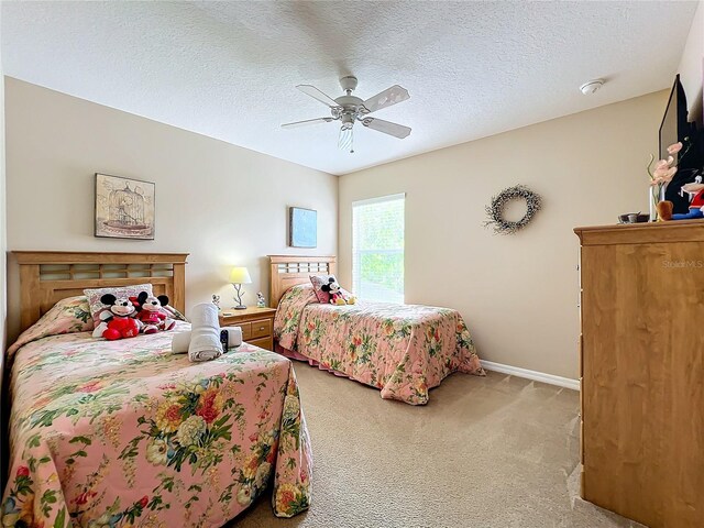 carpeted bedroom with ceiling fan and a textured ceiling