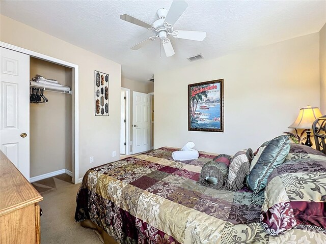 carpeted bedroom featuring ceiling fan, a closet, and a textured ceiling