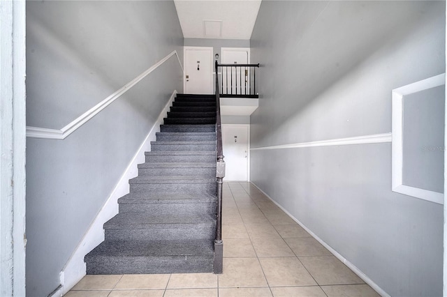 staircase featuring light tile patterned flooring