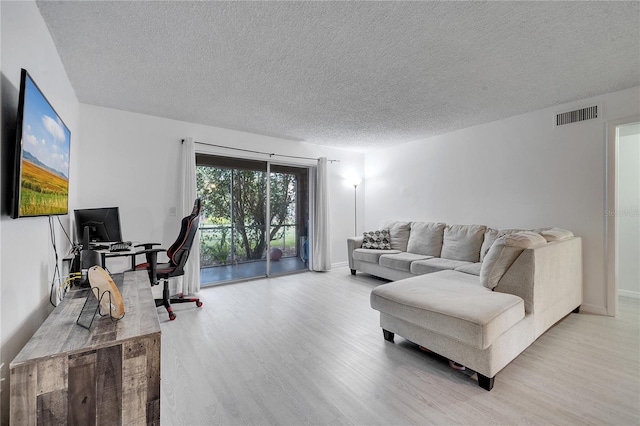 living room with light hardwood / wood-style flooring and a textured ceiling