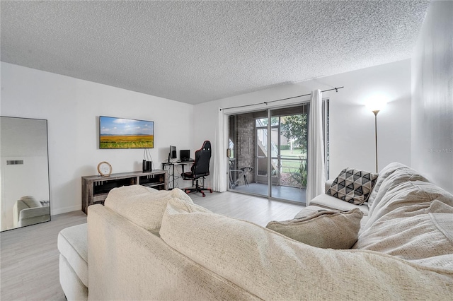 living room with light wood-type flooring and a textured ceiling