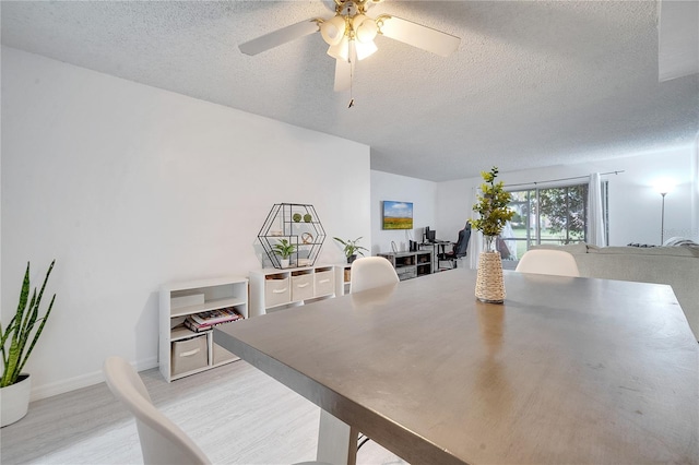 dining area with light hardwood / wood-style flooring, a textured ceiling, and ceiling fan