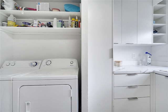 laundry room featuring cabinets and washing machine and clothes dryer