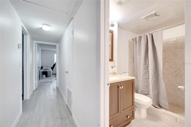 hallway featuring light wood-type flooring and a textured ceiling