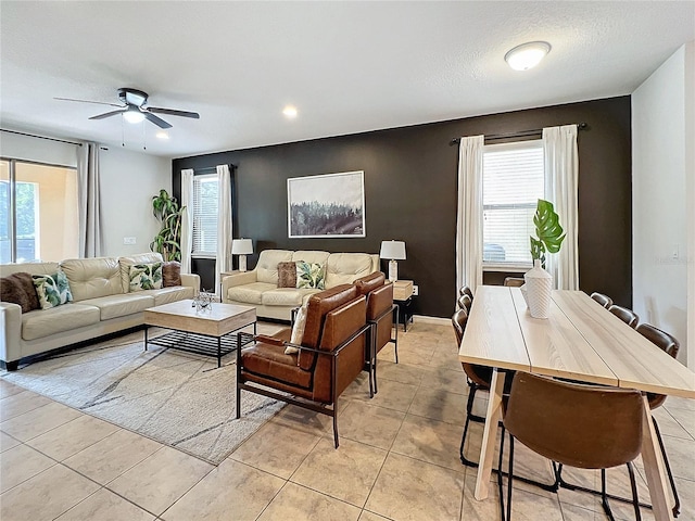 living room with light tile patterned flooring, a wealth of natural light, and ceiling fan